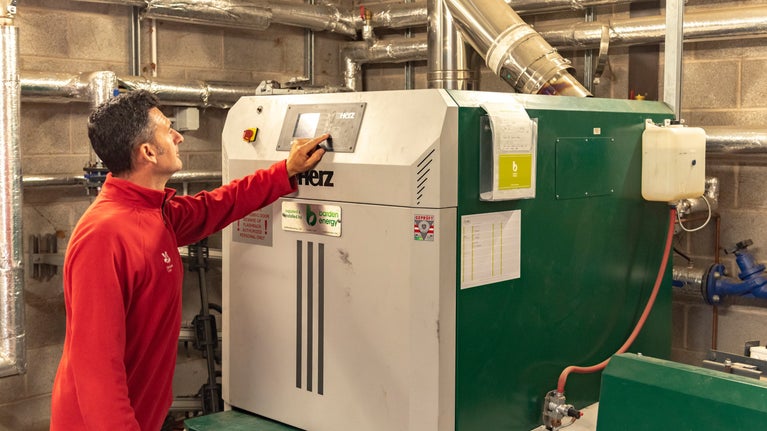 A member of staff tends to the biomass boiler at Great Langdale campsite in Cumbria